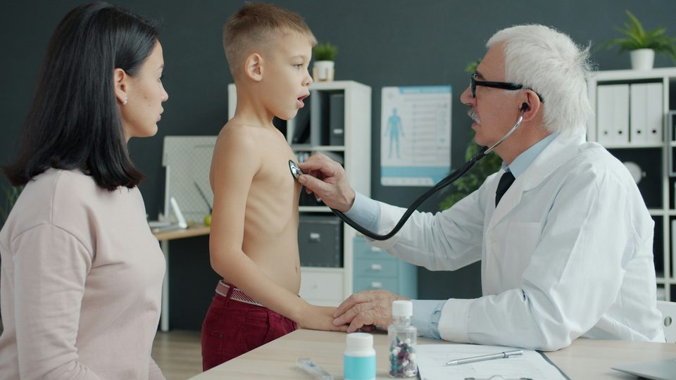Лікар оглядає дитину в присутності матері