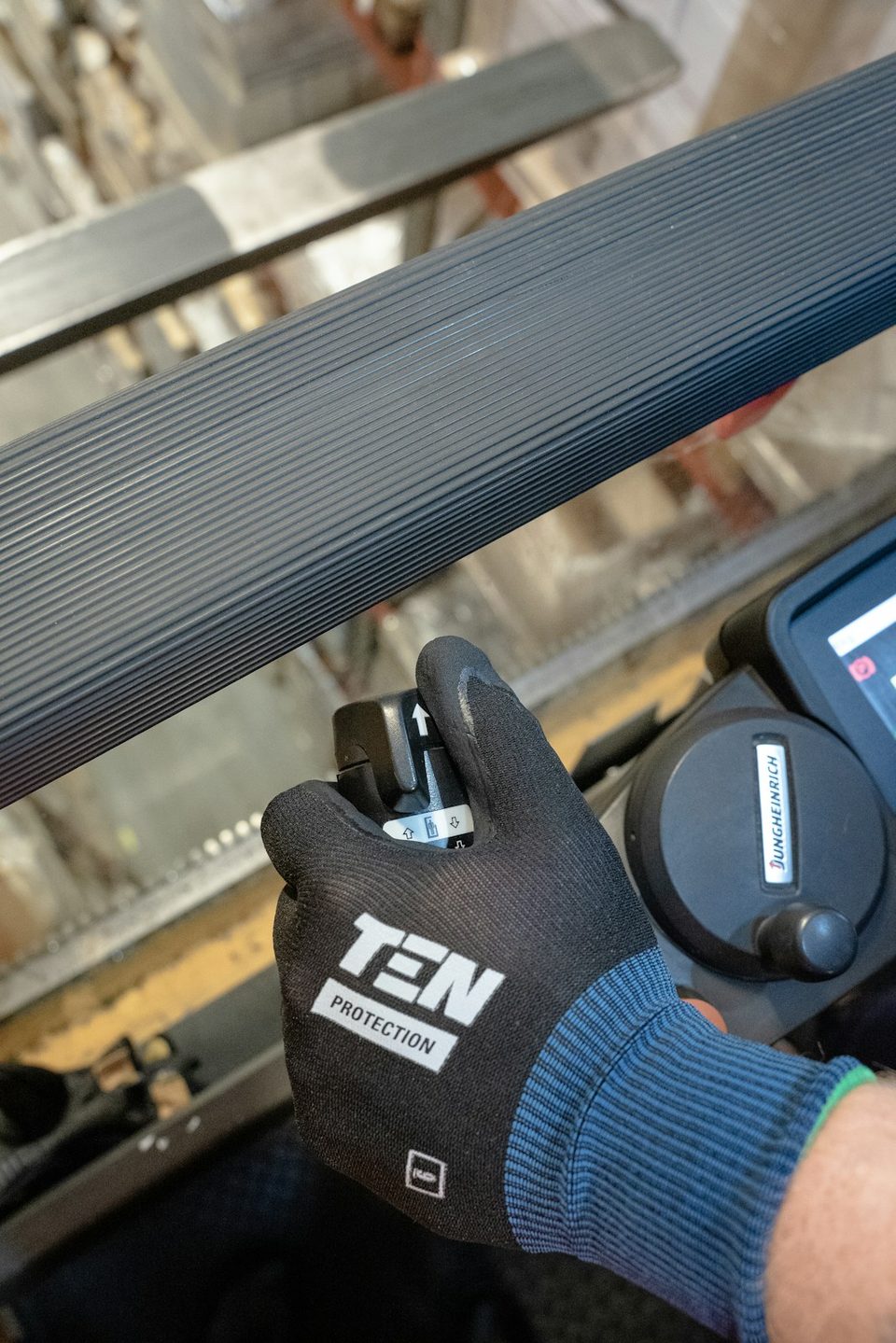 A worker’s gloved hand beside industrial equipment